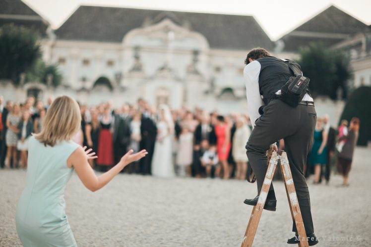 profesional wedding photographer on a ladder taking photos - Schloss Halbturn