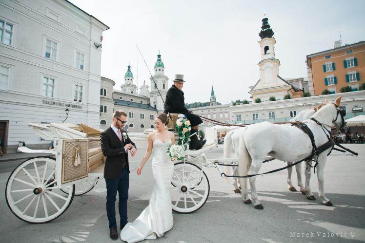 bride and groom on horse carriage in Salzburg Mozart's square