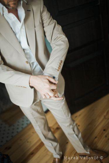 groom fetting ready - wearing creamy suit