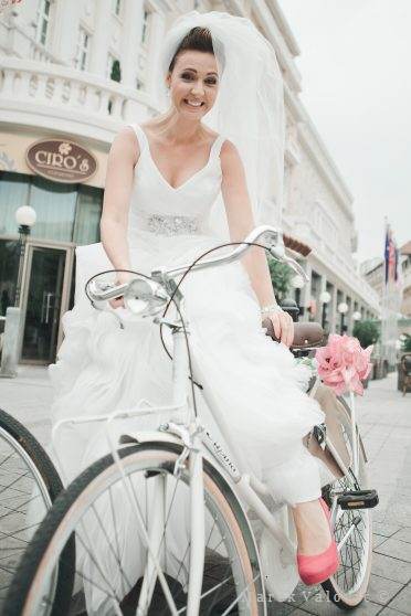 Biely bicykel na svadbe nevesta s ružovými topánkami